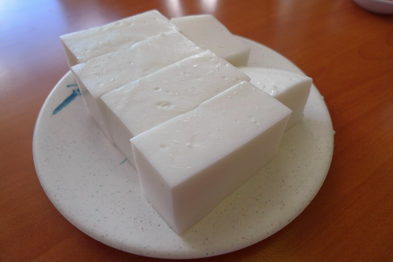 Squares of white haupia coconut pudding on a plate