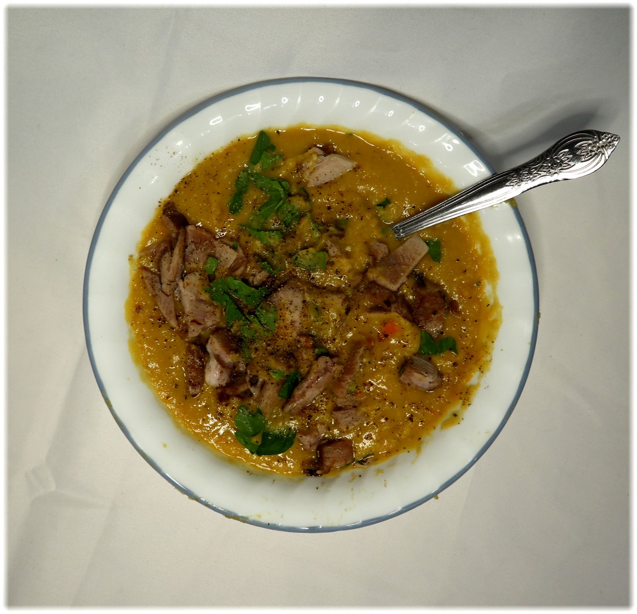 A bowl of Quebec-style yellow pea soup with ham and parsley