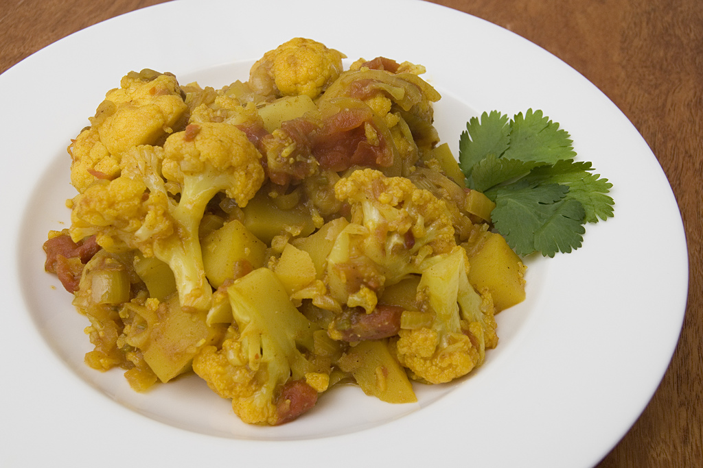 Aloo gobi potato and cauliflower curry on a white plate